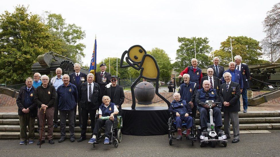 Veterans with the maquette of Atomic, by street artist Stik