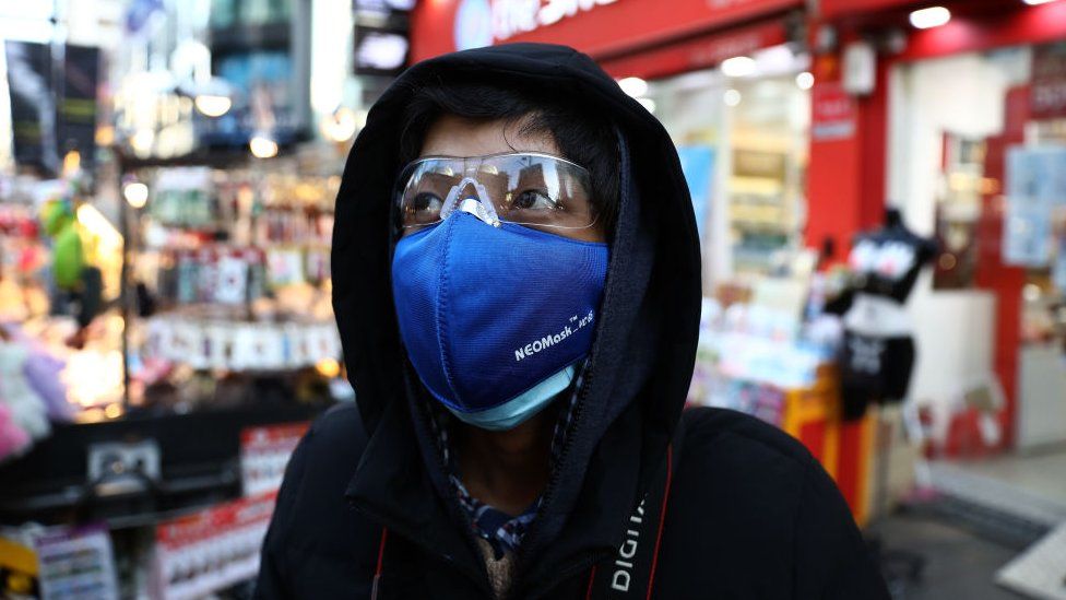 A man wears mask to prevent the coronavirus (COVID-19) walk along the Myungdong shopping district