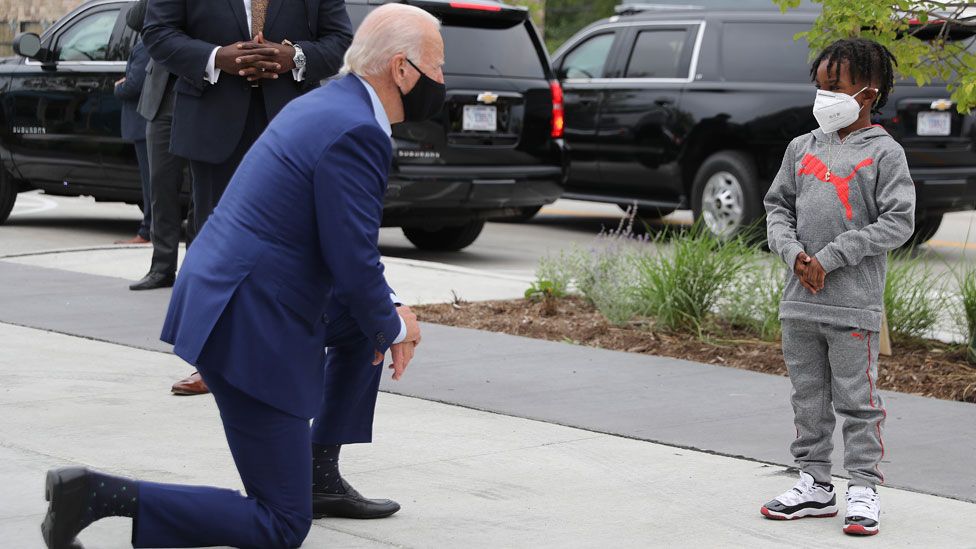 A masked Joe Biden meeting a boy on the campaign trail