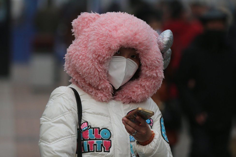A Chinese woman wearing mask walks in a shopping street during a hazy day in Beijing city, China, 22 December 2015