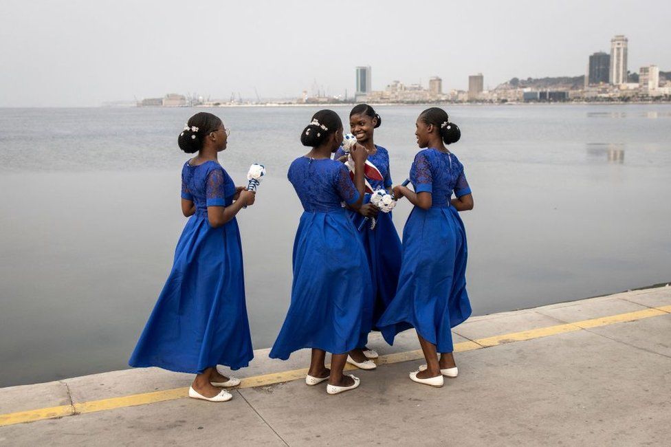 Bridesmaids gather along the promenade in Luanda.