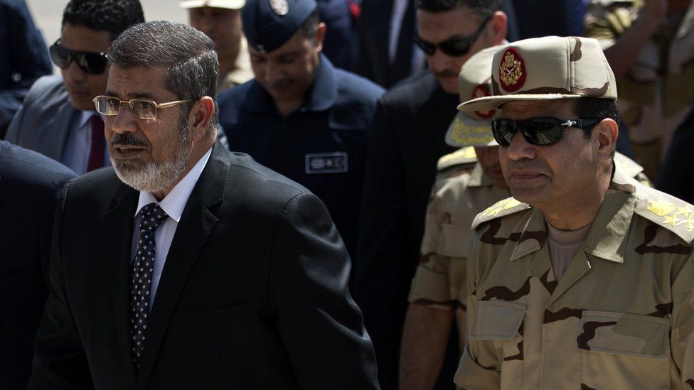 Mohammed Morsi (L) and Abdul Fattah al-Sisi (R) arrive at Almaza military airbase in Cairo (22 May 2013)