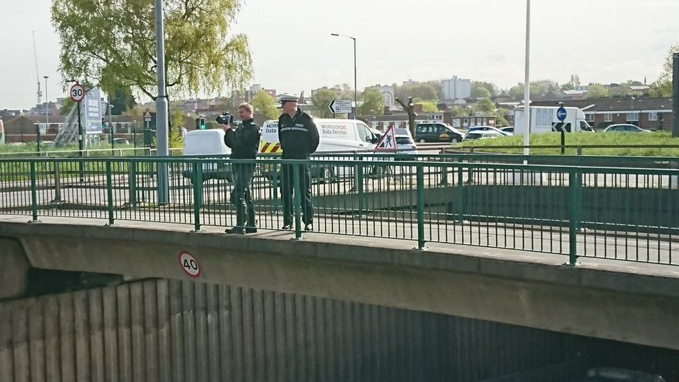 Officers on the bridge above the site