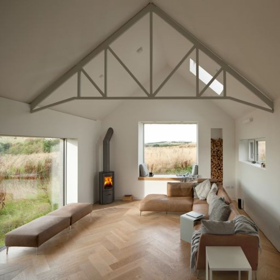 The interior of Cuddymoss showing a sitting area with log-burning stove and views of surrounding fields from the windows.