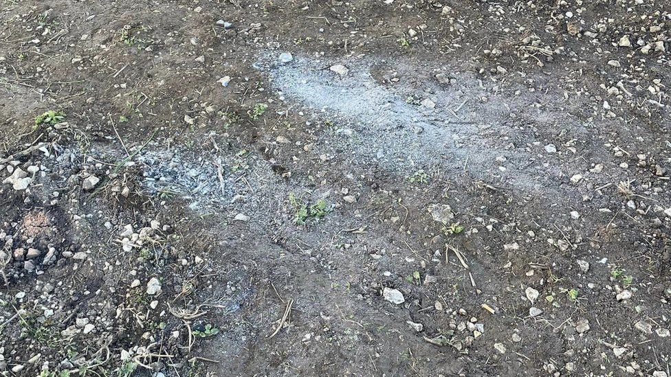 A photo of small ash marks left at the site following BBQs