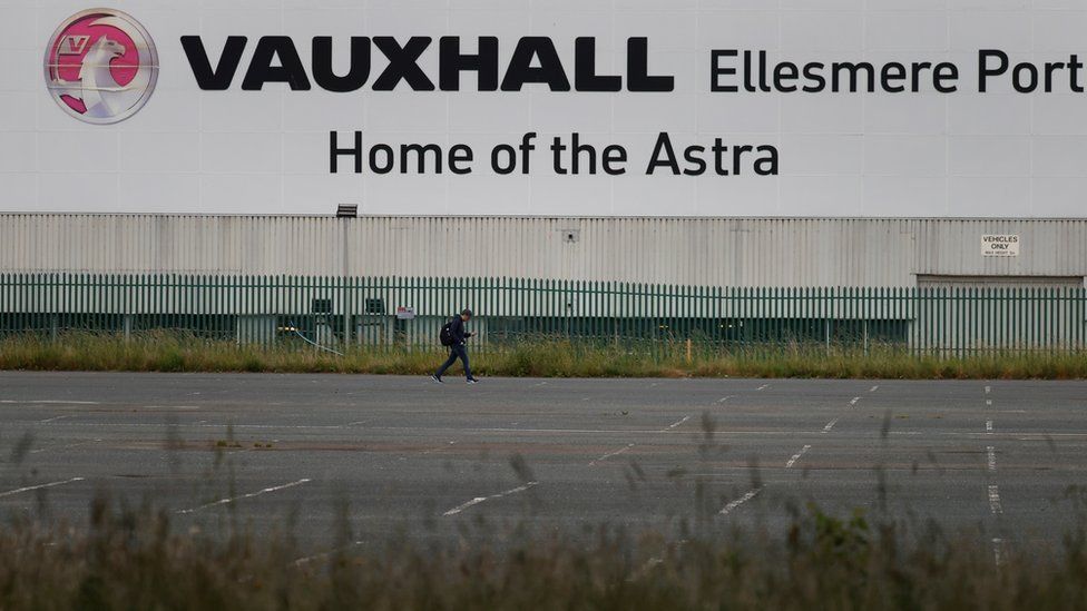 A man walks across an empty car park at the Vauxhall car plant in Ellesmere Port