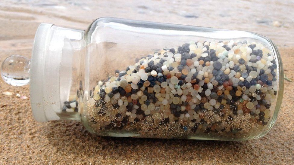 jar of nurdles on beach