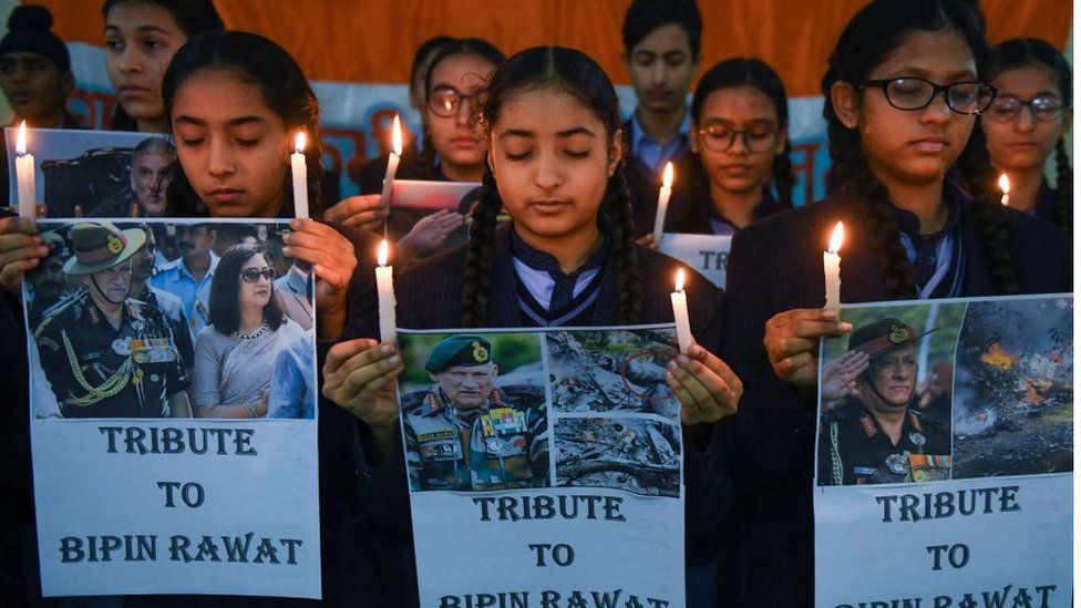 Студенты держат свечи и плакаты, чтобы отдать дань уважения главнокомандующему обороной Индии генералу Бипину Равату в своей школе в Амритсаре 9 декабря 2021 г.