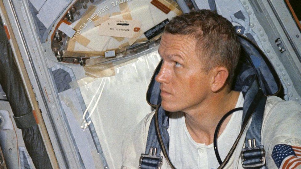 Frank Borman in spacecraft with a white t-shirt