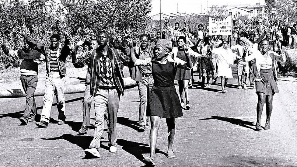 16 июня 1976 года ученики средней школы в Соуэто, Южная Африка, протестовали за лучшее образование. Полиция применила слезоточивый газ и боевые патроны в марширующую толпу, убив невинных людей, и зажгла так называемое «восстание в Соуэто», самый кровавый эпизод беспорядков между полицией и протестующими с 1960-х годов.