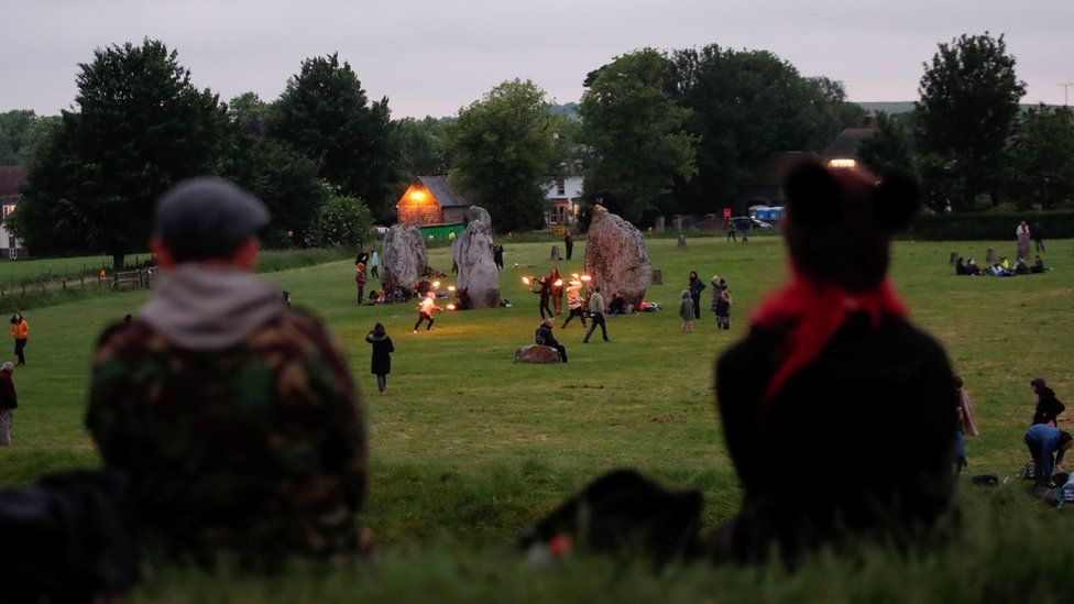 People celebrate the Summer Solstice in Avebury, despite official events being cancelled amid the spread of the coronavirus disease