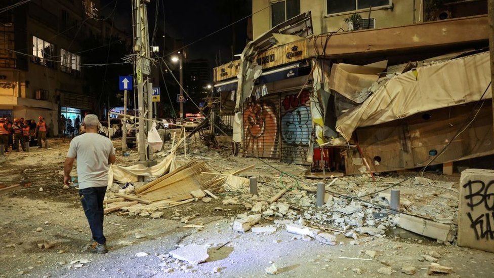 A man walks past a shop in tel Aviv hit by a rocket fired from Gaza