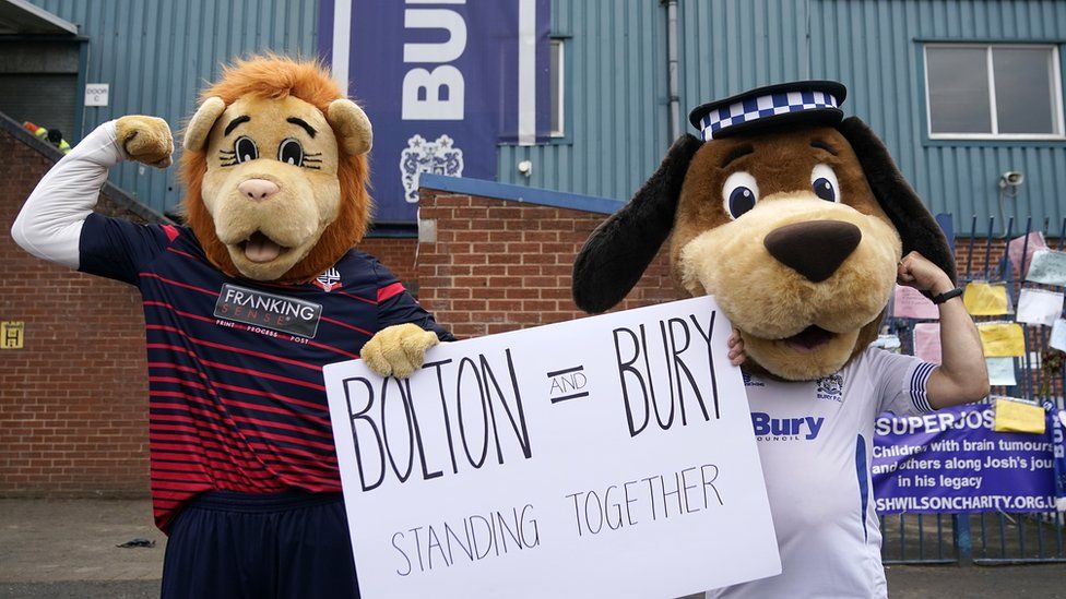 Bolton Wanderers and Bury FC mascots stand together in support of each other