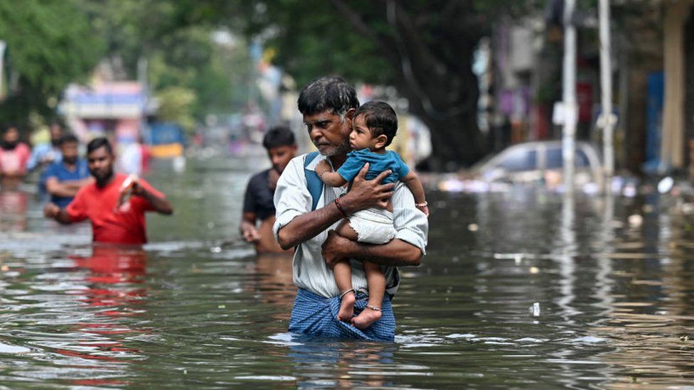People wade through a road in Chennai city on 6 December