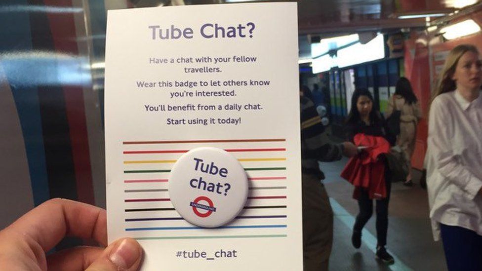 Handing holding a Tube Chat badge