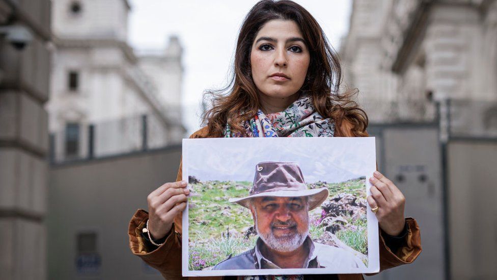 Roxanne Tahbaz holds a photograph of her father, Morad Tahbaz, outside the Foreign, Commonwealth and Development Office