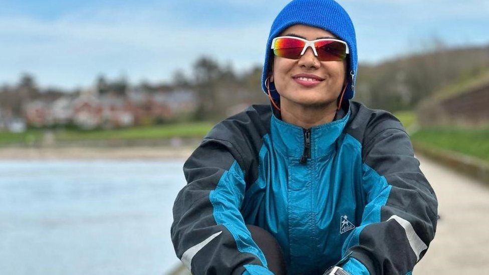 Diana Amini sits in her rowing gear by the Lagan