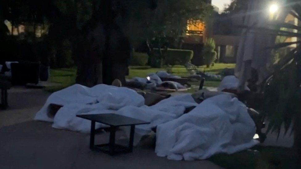 People sleeping outside near a hotel swimming pool in Marrakesh