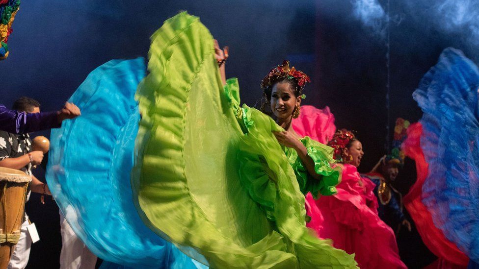 Dancers in colourful dresses performing on stage