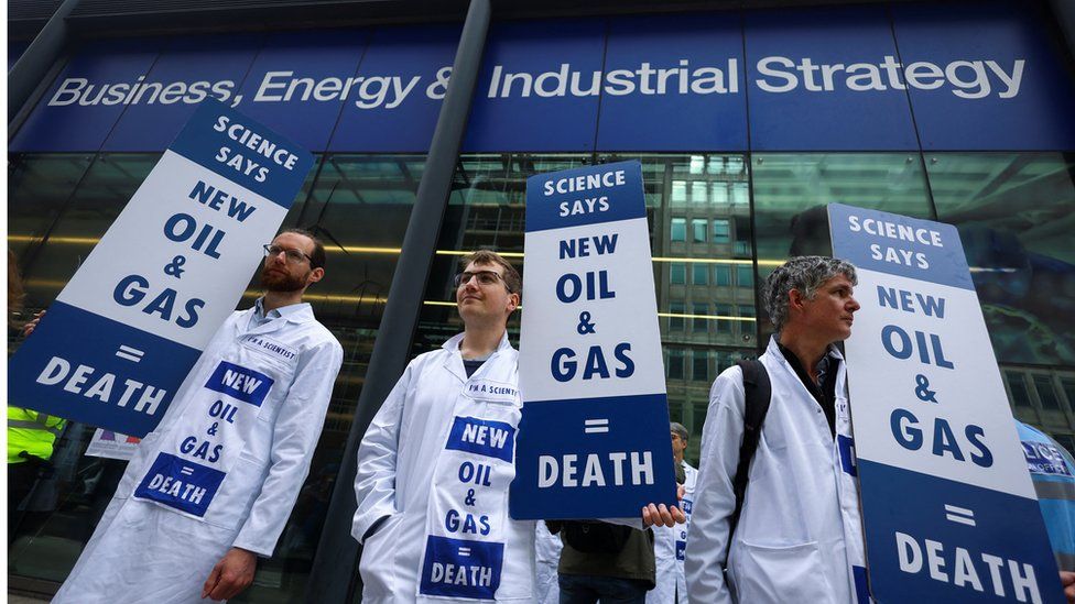 Activists from Extinction Rebellion hold placards at an entrance at the Department for Business, Energy & Industrial Strategy in London