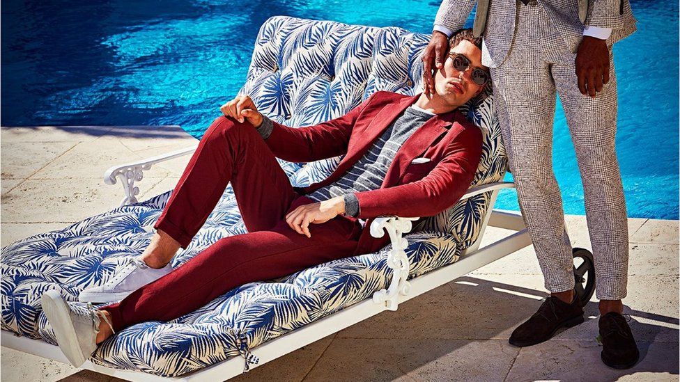 Image of Suitsupply advert showing two well-dressed men beside a pool