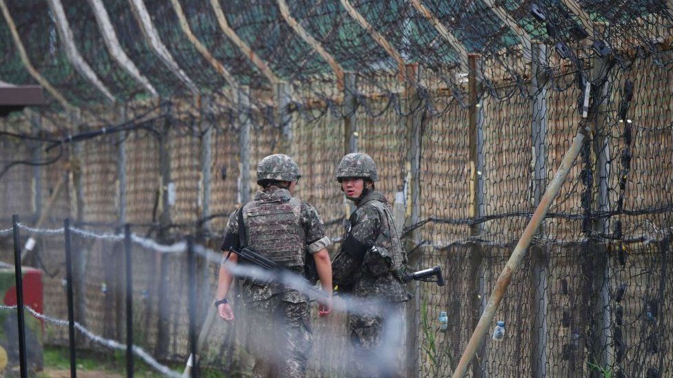 South Korean soldiers patrol along a fence in the Demilitarized zone