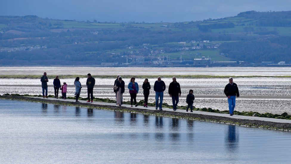 People walking across a marina