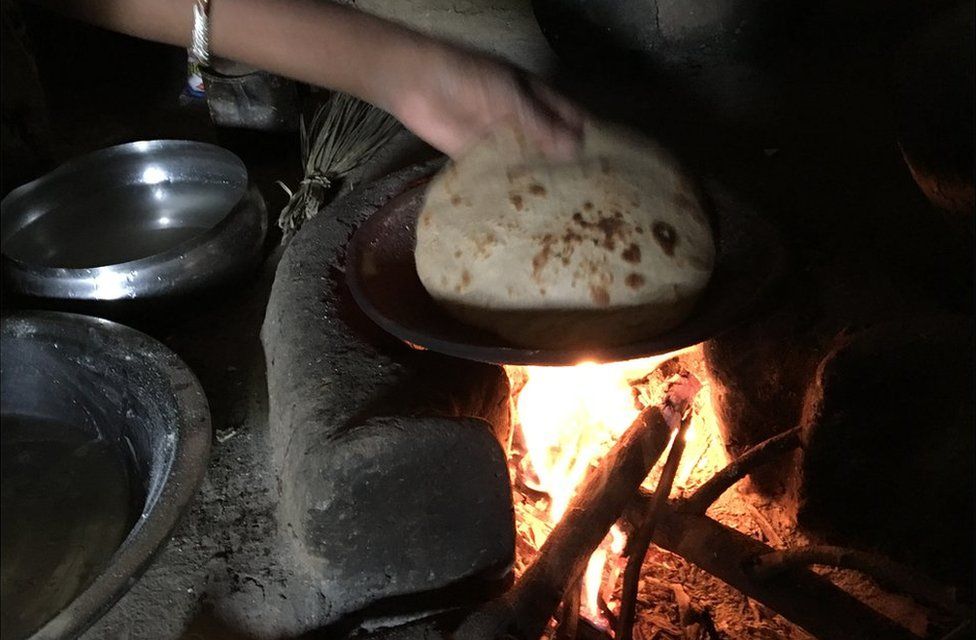 An Indian woman cooks bread