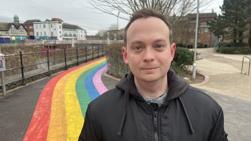 Rob Ewers stood in front of a rainbow pathway