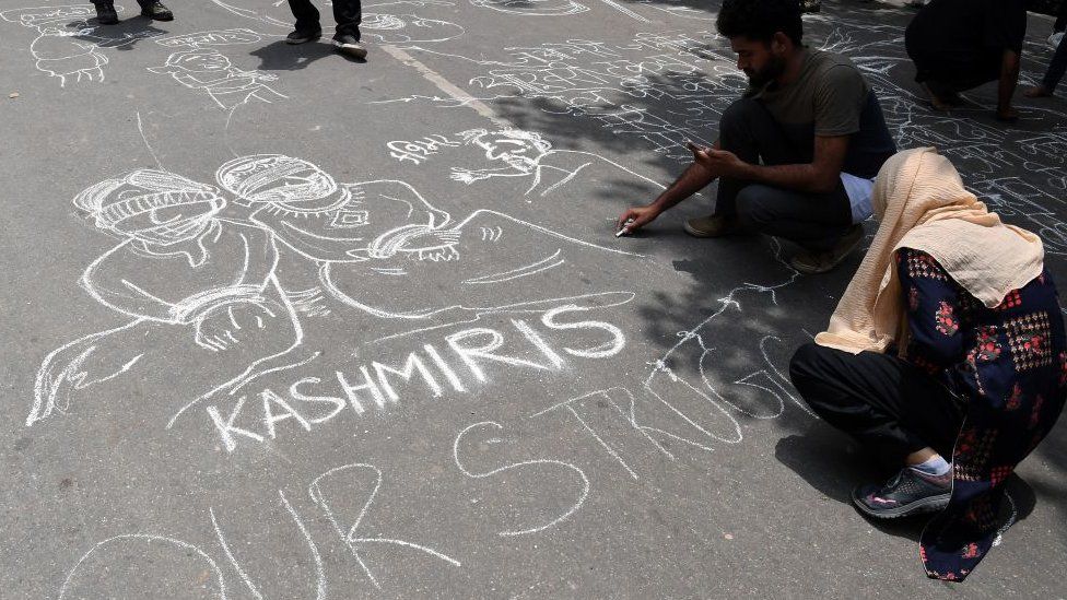 Communist Party of India (CPI) activists draw graffiti on the ground during a protest in New Delhi on August 7, 2019, in reaction to the Indian government scrapping Article 370 that granted a special status to Jammu and Kashmir.