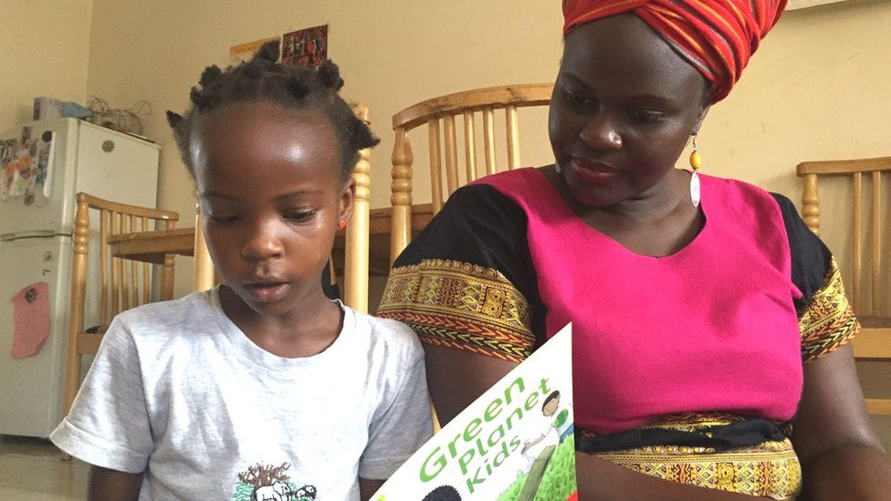 Beverley Nambozo reading with her daughter Zion, aged seven, in Kampala, Uganda