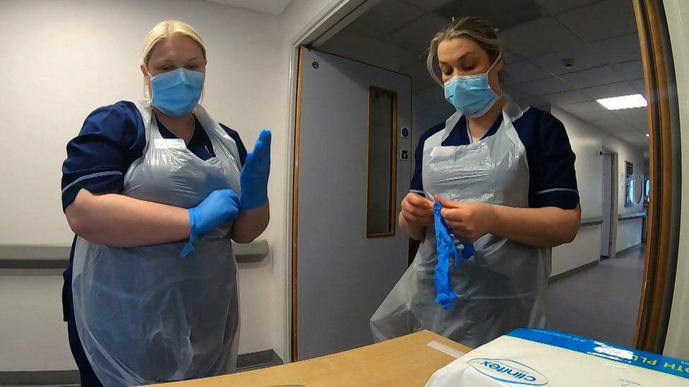 Nurses putting on PPE