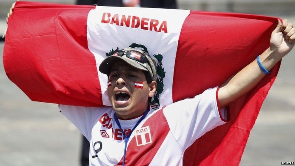 A supporter holds a Peruvian flag after knowing the final ruling court decision of a decades-old maritime dispute between Peru and Chile, at the Government Palace in Lima