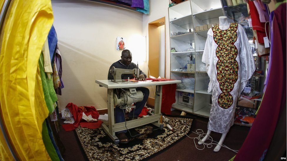 A fisheye lens view shows embroiderer Abdoulaye Bashiri from Ghana working on a dress at Mali South traditional African clothing store in Cape Town, South Africa - 29 July 2015