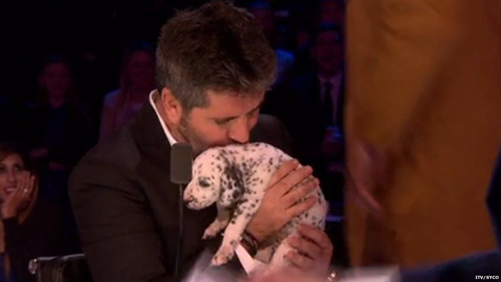 Simon Cowell kissing a puppy