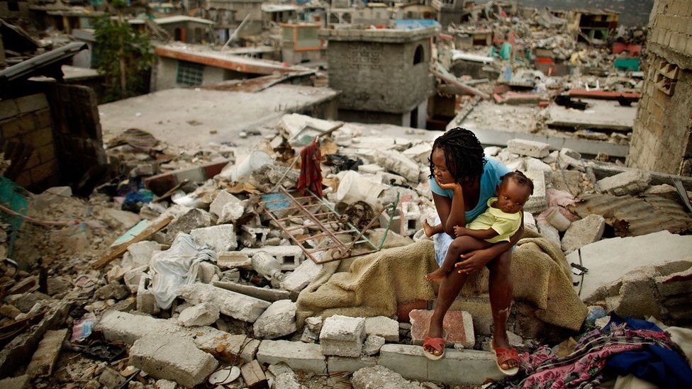 A mother and her daughter sit on the spot where their home collapsed during the earthquake, February 26 2010 in Port-au-Prince, Haiti.