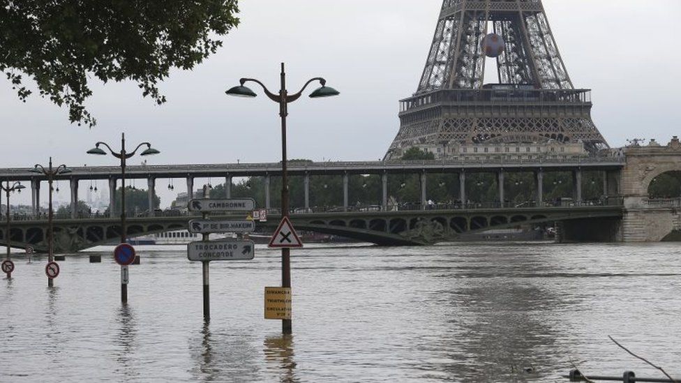 Road signs emerge on the banks of the Seine river next to the Bir Hakeim bridge and the Eiffel Tower during floods in Paris (04 June 2016)