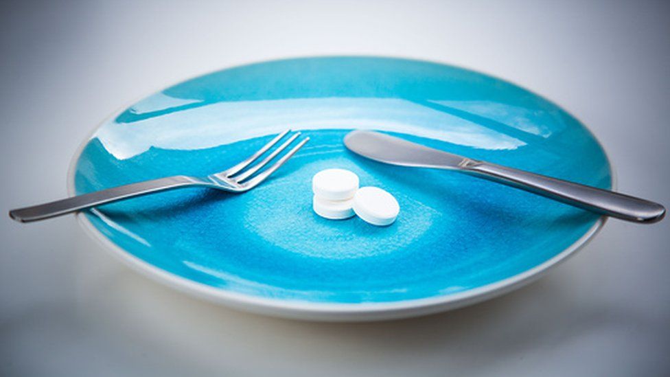 A plate with cutlery and pills