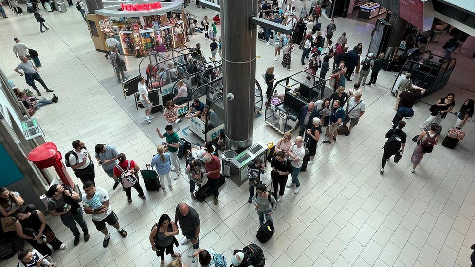 Gatwick airport, with queues and people sitting wherever they can