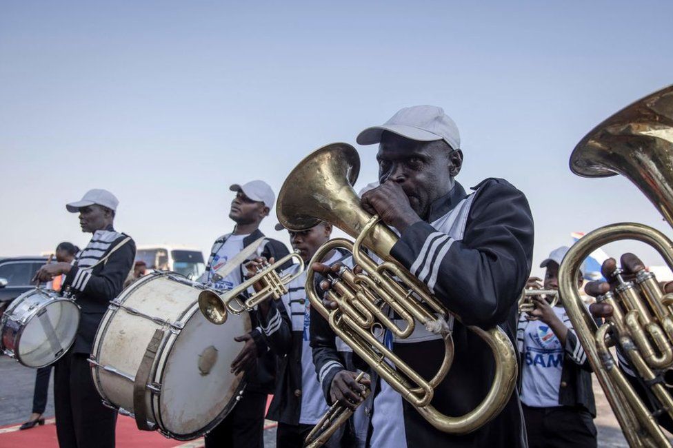 A brass band plays as the coffin of slain Congolese independence leader Patrice Lumumba leaves for Shilatembo where the leader was killed along with two of his compatriots at the airport in Lubumbashi on June 26, 2022