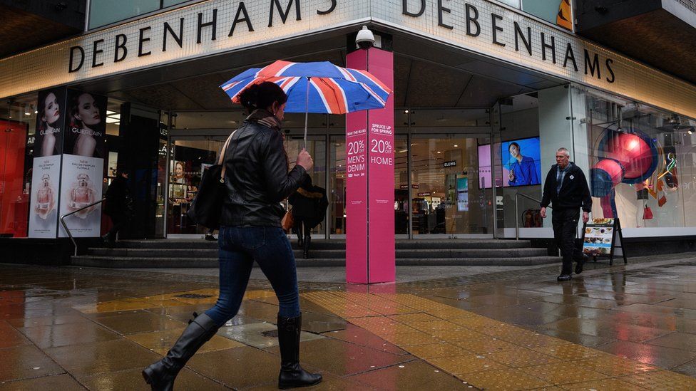 Shoppers pass a branch of the Debenhams chain of department stores on Oxford Street.