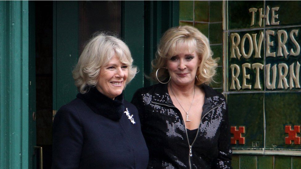 Camilla, Duchess of Cornwall laughs as she chats to cast member Beverley Callard outside the Rovers Return during a tour of the Coronation Street set on February 4, 2010