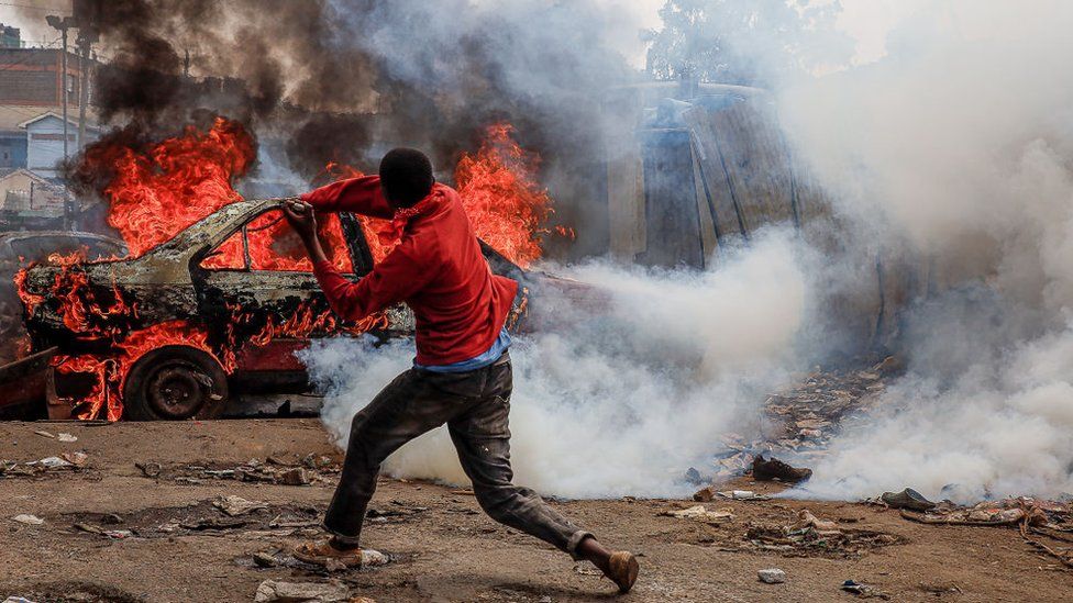 Протестующий бросает камни в полицию по охране общественного порядка во время акции протеста «Азимио ла Умоджа-Уан Кения» против высокой стоимости жизни 20 июля 2023 года в Найроби, Кения