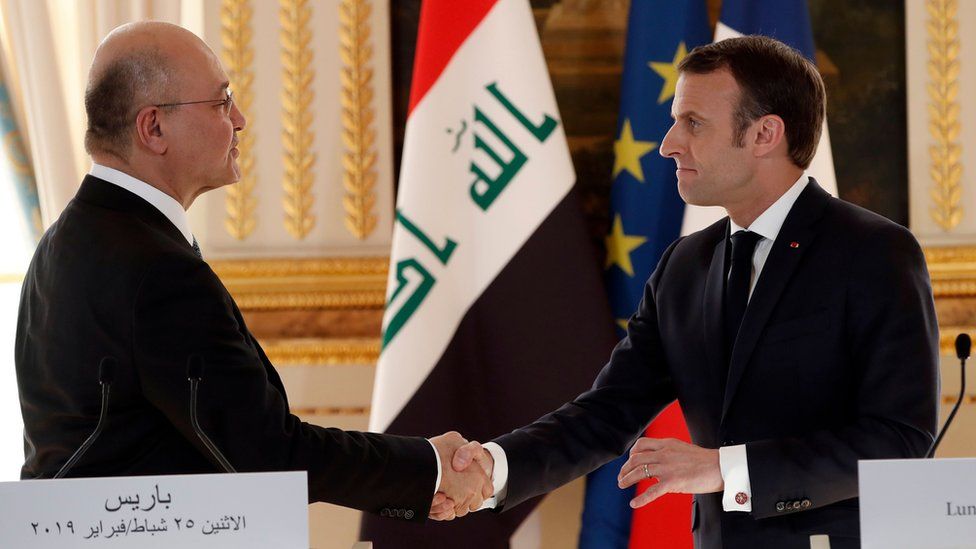 French President Emmanuel Macron (R) shakes hands with Iraqi President Barham Saleh as they attend a press conference at The Elysee Palace in Paris on February 25, 2019.