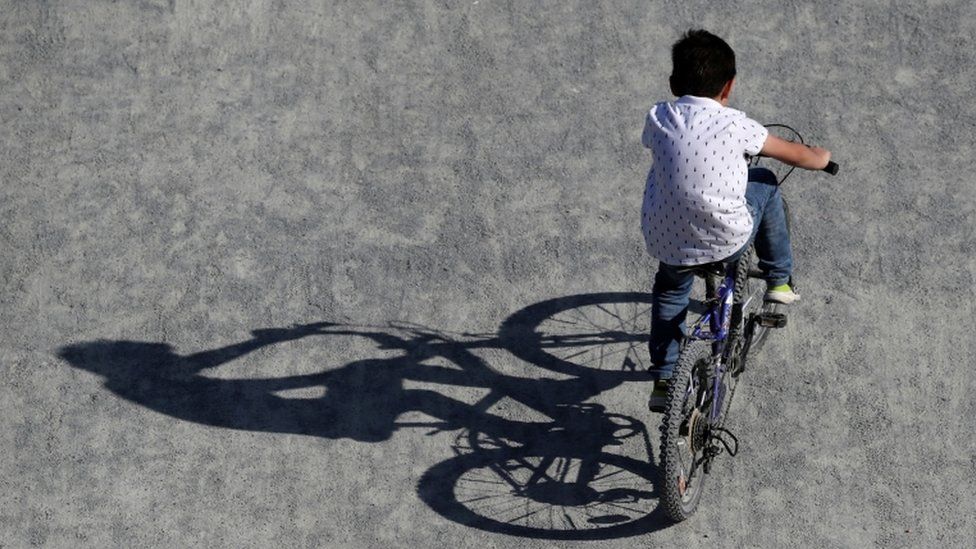 A boy rides a bicycle in a park in Brussels as Belgium remains under lockdown