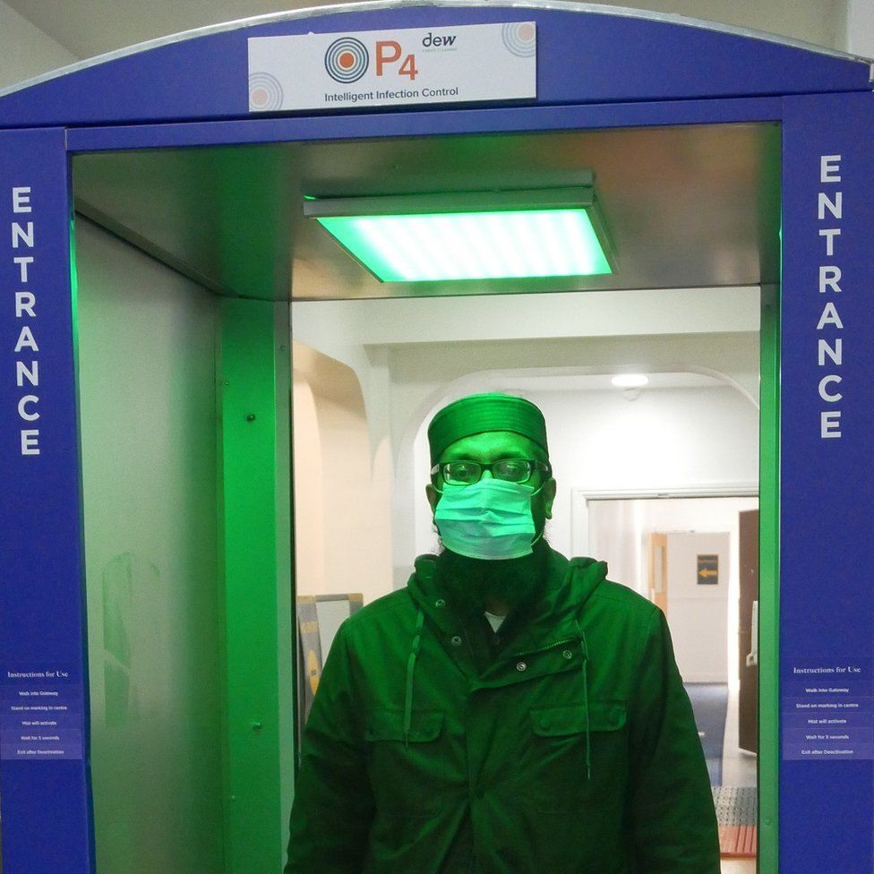 Man walking through sanitiser in mosque