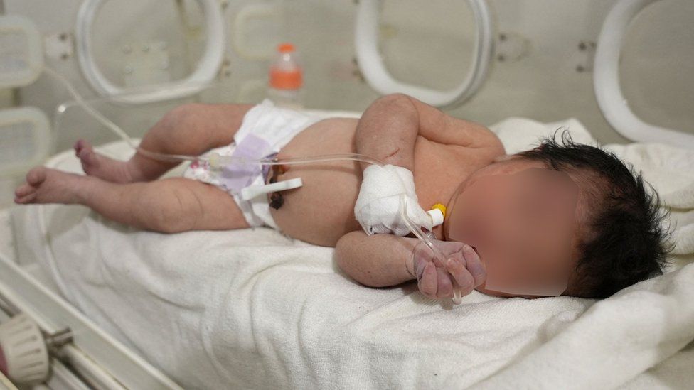 A newborn baby pulled from the rubble of a destroyed building in Jindayris, Syria, receives treatment at a hospital (7 February 2023)