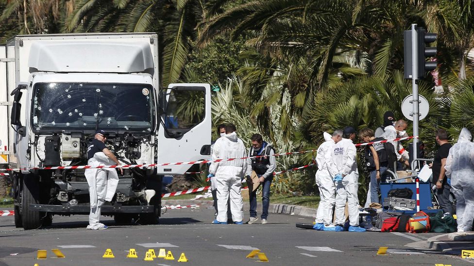 Полицейские следователи на месте происшествия возле тяжелого грузовика, въехавшего в толпу в Ницце в 2016 году