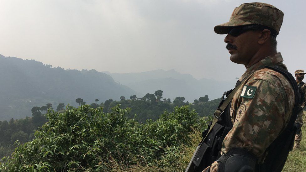 A Pakistani soldier stands guard in the mountainous region near the LOC.