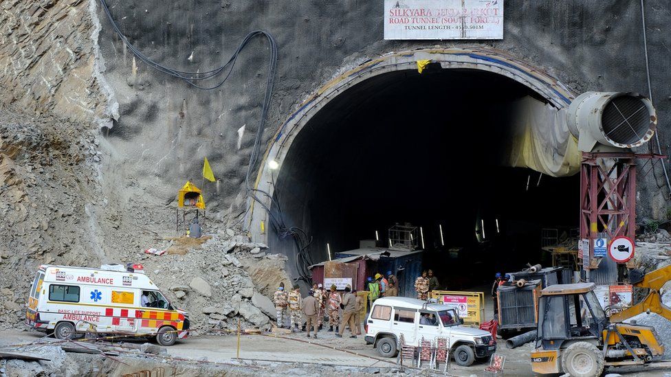 Ambulances and men waiting outside a tunnel